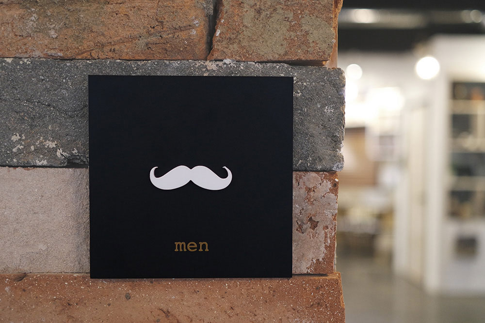 콧수염모양으로 표현한 남자 화장실표지판