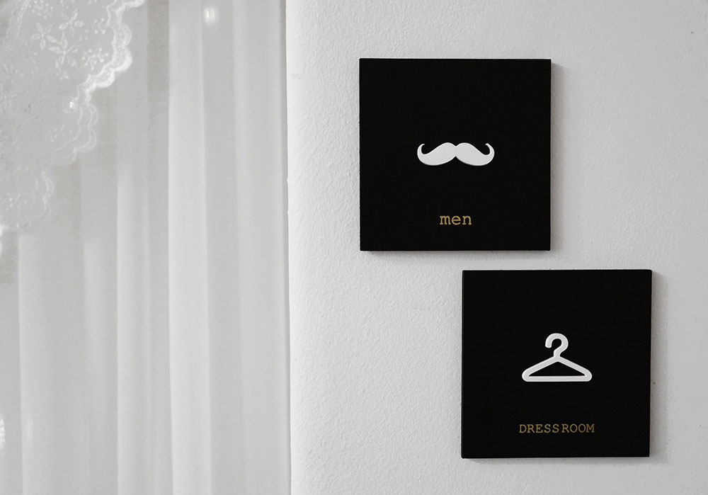 콧수염모양의 남자 화장실표지판과 옷걸이모양의 드레스룸 표지판