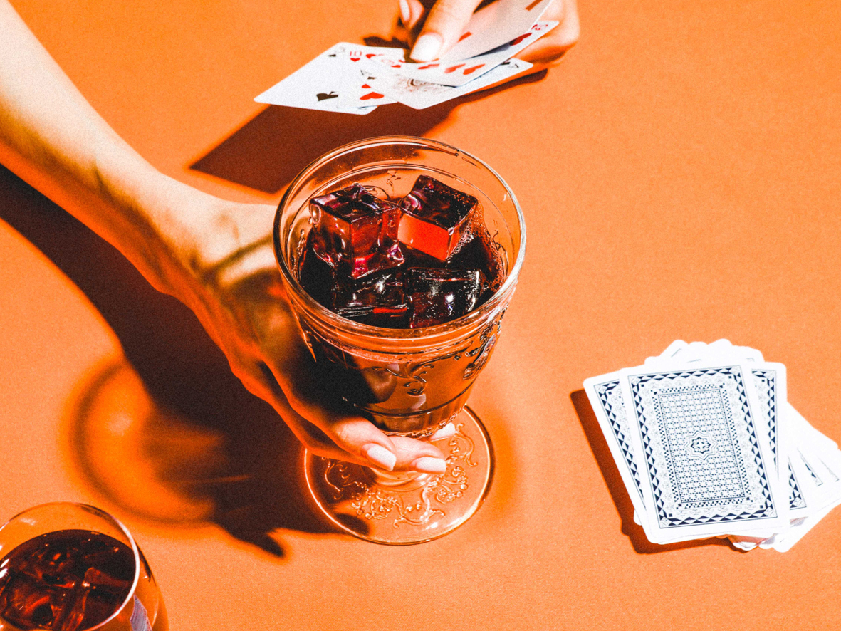Back of a man at a concert. Hes wearing a beanie hat and a baggy denim jacket with studs. Photo with a purple hue